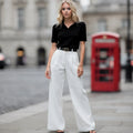 View of relaxed fit wide leg full length casual pants in soft beige fabric, featuring a comfortable waistband and flowing silhouette