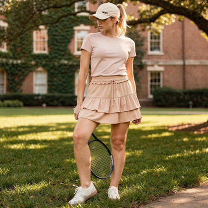 Light pink mini ruffle skirt with built in anti exposure shorts, detailed view highlighting fabric texture and ruffle design