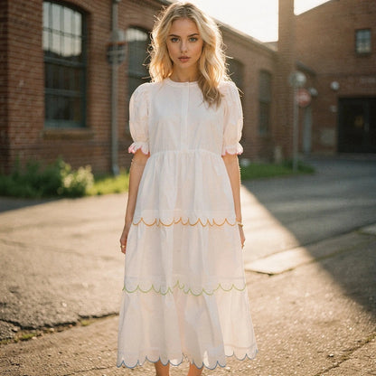 View of a flowy A line midi dress in soft pastel pink, featuring a round neck and delicate fabric draping