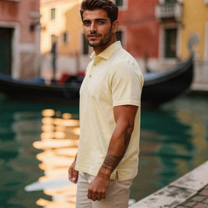 View of a navy blue slim fit short sleeve polo shirt featuring a V neck and soft cotton material