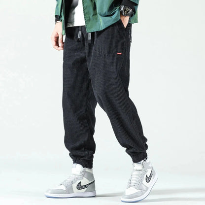 View of relaxed fit tapered joggers in soft beige corduroy, featuring a drawstring waistband and pockets