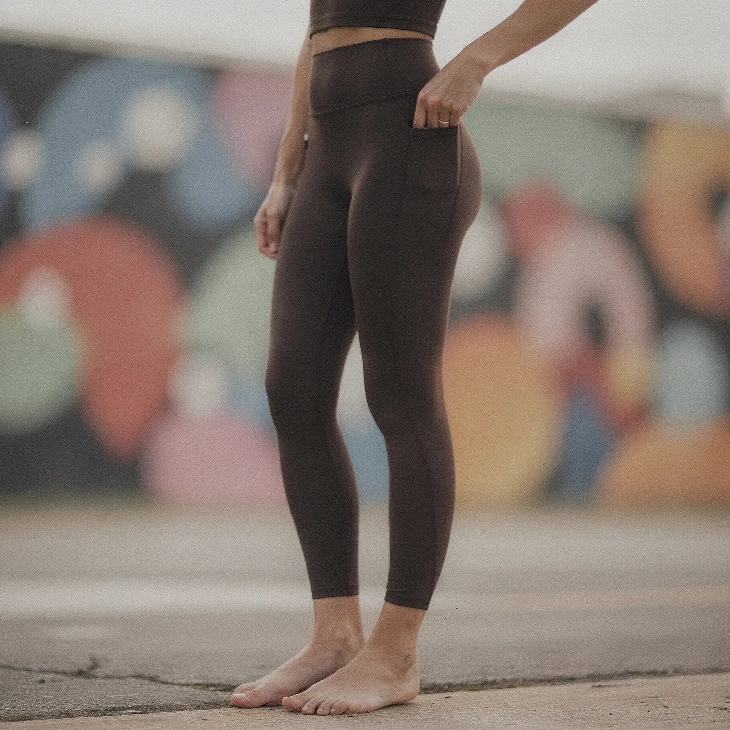 Black high waisted fitted 78 leggings with pockets, view showcasing stretchy material and sleek design