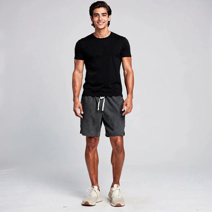 View of relaxed fit summer shorts featuring a striped pattern, drawstring waist, and lightweight fabric in shades of blue and white
