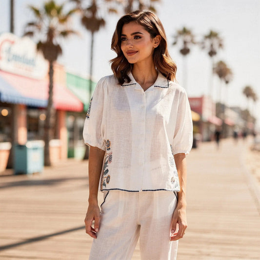 View of a relaxed fit short sleeve button down shirt featuring floral embroidery on a light fabric, perfect for casual wear